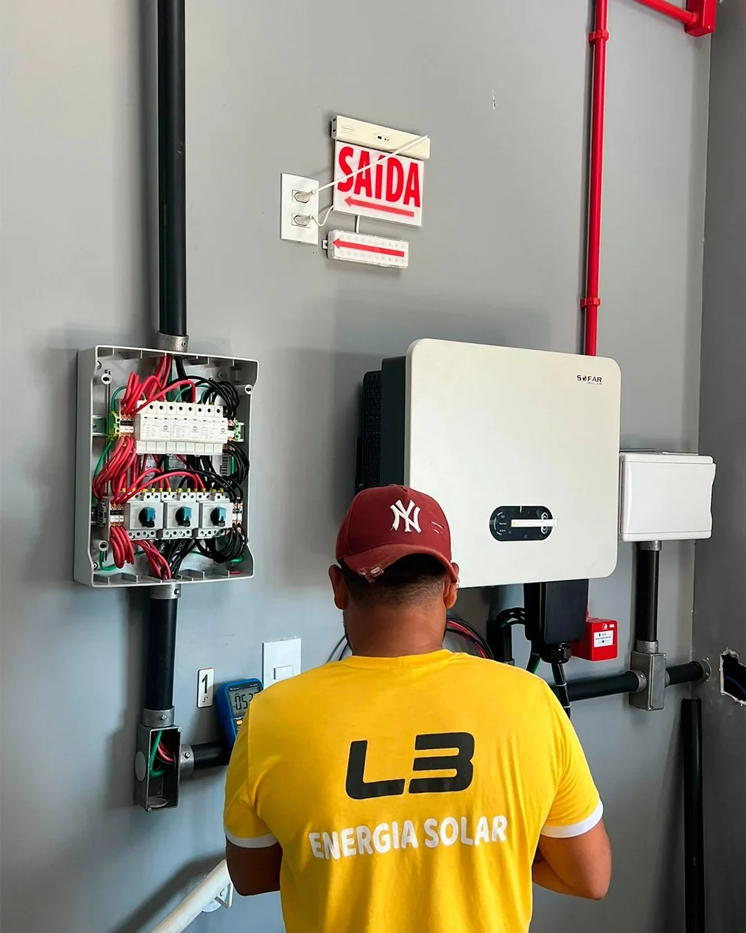 Pessoa com uniforme L3 junto a equipamentos elétricos